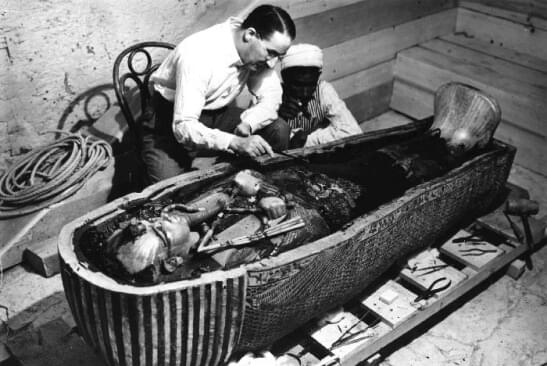 Archeologen bestuderen een open Egyptische sarcofaag