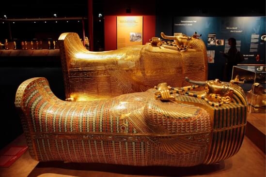 Two golden Egyptian caskets on display